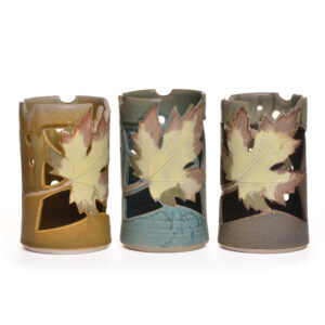 Wheel thrown ceramic lantern with cut-out leaf design. Artist Travis Berning creates this luminary on the potters wheel, adds leaf decoration, and finishes it with a drippy glaze.