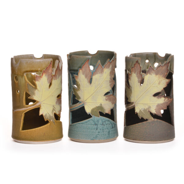 Wheel thrown ceramic lantern with cut-out leaf design. Artist Travis Berning creates this luminary on the potters wheel, adds leaf decoration, and finishes it with a drippy glaze.