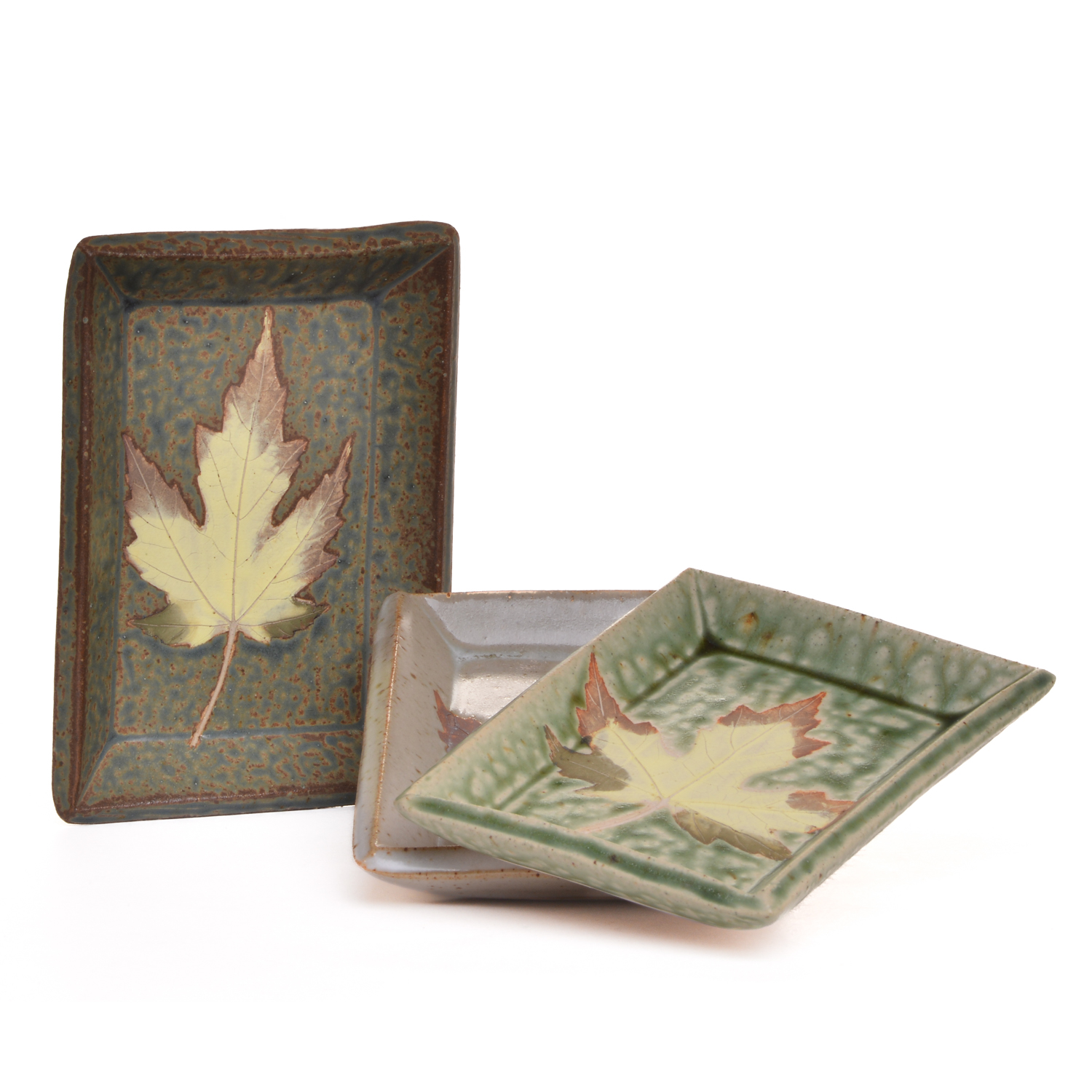 Small rectangle dish with leaf decoration. Great as a soap dish, spoon rest or trinket tray. Artist Travis Berning creates this small dish with a slab of clay, then adds a leaf decoration. The dishes are dipped in a drippy glaze.