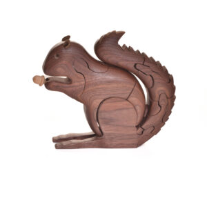 Squirrel with an acorn wooden puzzle. Artist Peter Chapman has developed a unique technique of cutting a single piece of wood into a three-dimensional interlocking puzzle. The result is an animal that articulates and moves like the creature it represents. Each piece comes with care and instructions.