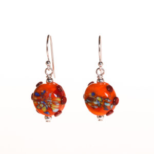 Handmade orange button tab glass bead earrings created over a torch. Teresa Brittain creates glass beads over a torch, using the centuries-old technique of lampworking, then combines the beads with sterling silver findings and chains to create unique pieces of wearable art.