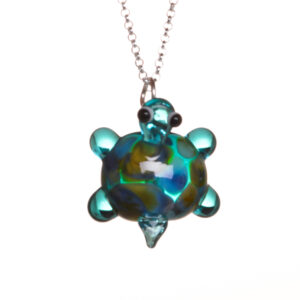 Handmade playful glass turtle critter bead pendant created over a torch. Teresa Brittain creates glass beads over a torch, using the centuries-old technique of lampworking, then combines the beads with sterling silver findings and chains to create unique pieces of wearable art.
