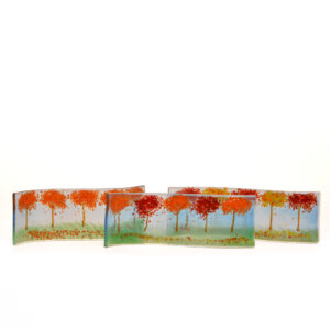 A beautiful landscape of fall trees, composed of colored glass chips (frit) and pulled elements, fused to a piece of glass, then slumped onto a wave mold so that they are free standing. Expect slight variations in color and design.