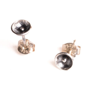 These are tiny fine silver disks rounded into bowls with a tiny ball in the center to resemble a poppy. They are made using the ancient technique of precision fusing called granulation. Each piece is cast in sterling silver. The earrings have a dark patina in the recesses and the tops are polished for contrast.