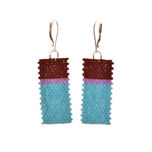 Flat geometric color-block earrings featuring peyote stitch and glass seed beads by jeweler Leslie Fawcett of Tennessee. With a needle and nylon thread, Leslie takes tiny glass seed beads and weaves them into a rectangular piece that is then rolled up and sewn together. The use of the peyote stitch allows the ends of the rectangle to interlock when sewn together, and repeated passes through the beads reinforce the whole.