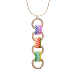 Silver linked pendant with interlocking handwoven glass seed beads by jeweler Leslie Fawcett of Tennessee. With a needle and nylon thread, Leslie takes tiny glass seed beads and weaves them into larger beads that are then rolled up and sewn together. Matching earrings available.