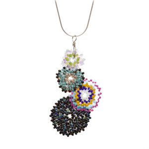 This unique pendant features a cluster of four handwoven glass seed beads by jeweler Leslie Fawcett of Tennessee. With a needle and nylon thread, Leslie takes tiny glass seed beads and weaves them into larger beads that are then rolled up and sewn together. The use of the peyote stitch allows the ends of the discs to interlock when sewn together, and repeated passes through the beads reinforce the whole.