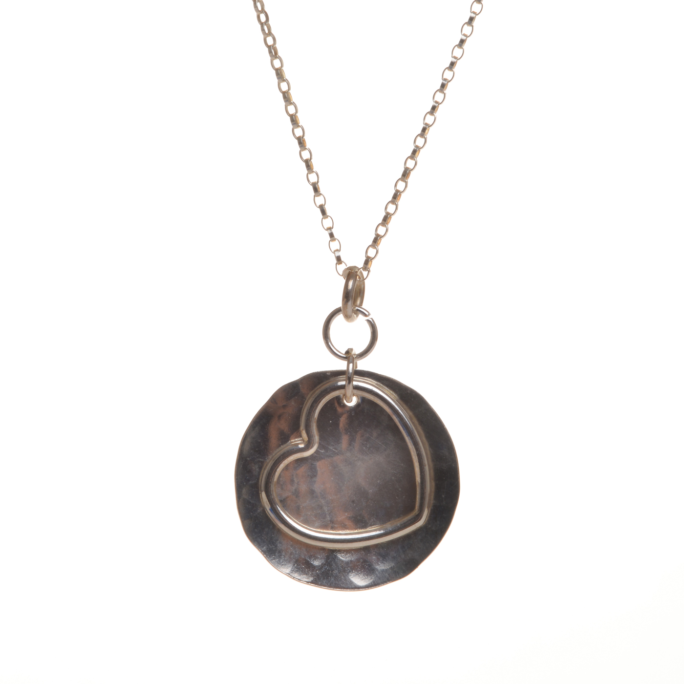 Handcrafted sterling silver heart on sterling silver hammered disc pendant featuring a free flowing heart dancing on a brilliantly shining disc. Designed and crafted by silversmith Suzanne Farran-Hrytzik of North Carolina. Great for everyday wear. Expect slight variations in design. Matching earrings available.