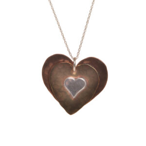 Handcrafted mixed metal heart necklace by silversmith Suzanne Farran-Hrytzik of North Carolina. This piece features contrasting hammered and layered hearts made of copper, brass, and sterling silver. Great for everyday wear. Expect slight variations in design.