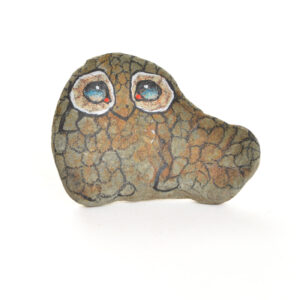 Hand painted river rock owl pin by Mänya Pirkle of Tennessee. Each pin features a natural river stone sourced from the mountains, transformed into a whimsical owl with unique features. No two owls are exactly alike, making each pin a special, wearable piece of folk art.