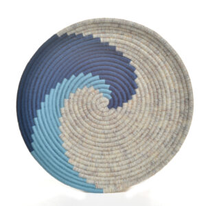 Handmade coiled rope wave wall décor by artist Ann Oakes of North Carolina. Each bowl is a vibrant and unique piece of textile art. The durable rope core is meticulously wrapped in yarn, forming an eye-catching spiral wave design in shades of blues and creams. Loop added to back for hanging. Spot clean with a damp cloth or vacuum with a small vacuum cleaner.