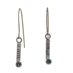 Delicate silver drop earrings featuring a sleek, textured bar design accented with a sparkling blue topaz, biologically inspired and designed by Charity Hall of Virginia.