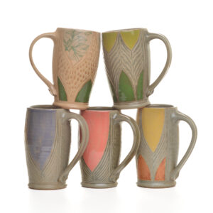 Tall wheel-thrown stoneware mug that combines functional design with intricate botanical artistry by North Carolina potter Robin Kirby Bryant. The original designs are hand-carved and painted on each piece. No two are alike, though they will share the feeling of belonging together. Dishwasher and microwave-safe. Different colors and designs available. Each sold separately.