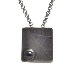 Argentium silver pendant with a leaf texture, accented with a hematite cabochon. The leaf texture is subtle and adds interest. Each item is unique, and no two are exactly the same.