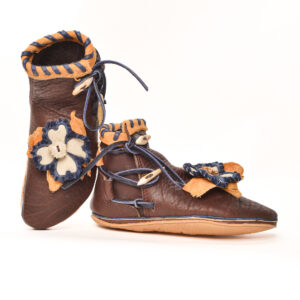 Anika Jaan 2025, American bison hide, elk hide, deer hide, elk antler crowns and tines, nylon thread; tanning, sewing, polishing 5" x 4" x 10 ½", approximately women's size 7 ½ (custom-fitted commissions encouraged)