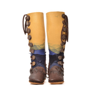 Anika Jaan 2026, American bison hide, deer hide, elk antler, walnut dye, indigo dye, nylon thread; tanning, layered deer hide natural edge appliques, indigo dye painted mountains 16" x 4" x 10 ½", approximately women's size 7 ½ (custom-fitted commissions encouraged)