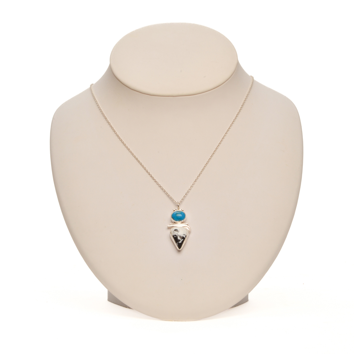 "Riders in the Sky" handcrafted sterling silver pendant featuring bold White Buffalo stone and Kingman turquoise by Ruthie Cohen of North Carolina. Bold contrasting colors and geometric lines merge seamlessly, creating a stunning statement piece.